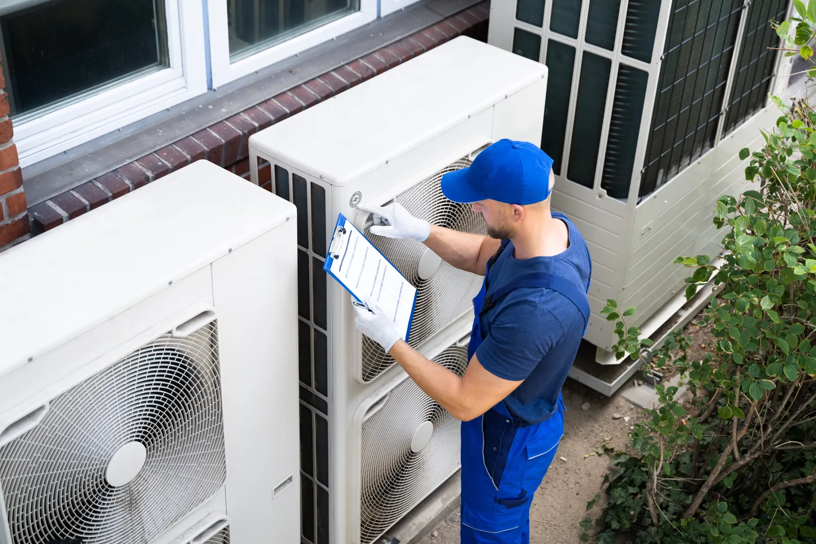 HVAC technician inspecting units with a checklist