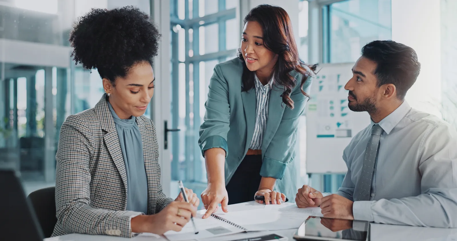 Sales team marking up proposal documents at a table
